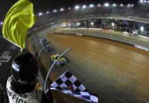 BRISTOL, TENNESSEE - APRIL 09: Christopher Bell, driver of the #20 DeWalt Power Stack Toyota, takes the checkered flag under caution to win the NASCAR Cup Series Food City Dirt Race at Bristol Motor Speedway on April 09, 2023 in Bristol, Tennessee
