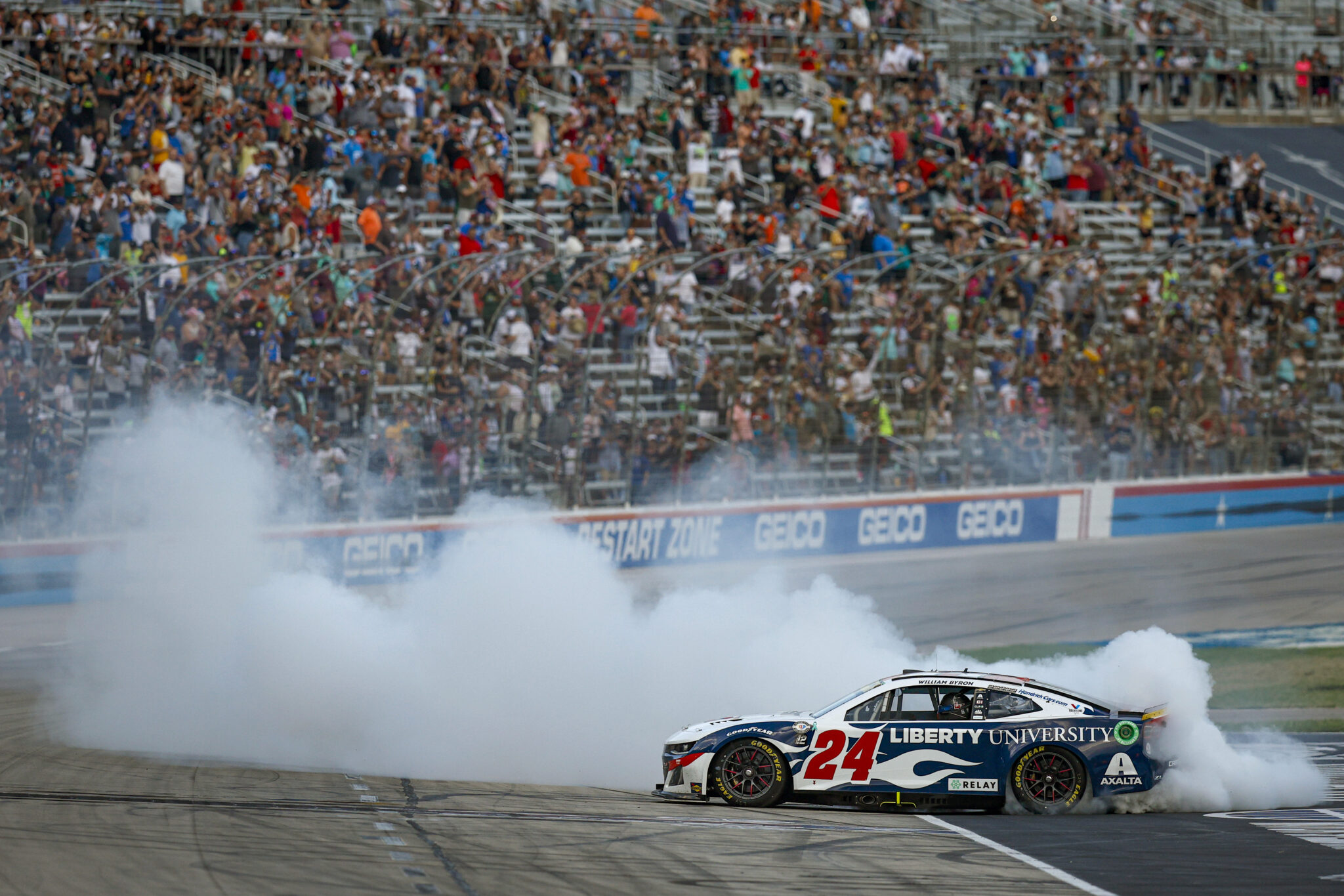 FORT WORTH, TEXAS - SEPTEMBER 24: William Byron, driver of the #24 Liberty University Chevrolet, celebrates with a burnout after winning the NASCAR Cup Series Autotrader EchoPark Automotive 400 at Texas Motor Speedway on September 24, 2023 in Fort Worth, Texas.