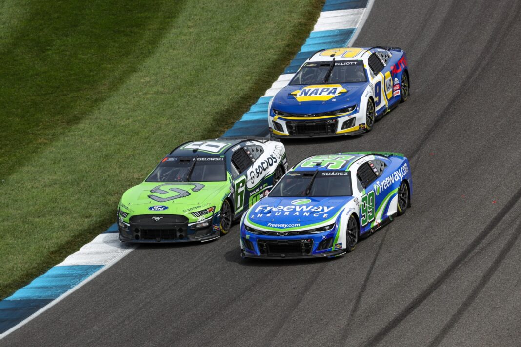 INDIANAPOLIS, INDIANA - AUGUST 13: Brad Keselowski, driver of the #6 Socios.com Ford, Daniel Suarez, driver of the #99 Freeway.com Chevrolet, and Chase Elliott, driver of the #9 NAPA Auto Parts Chevrolet, race during the NASCAR Cup Series Verizon 200 at the Brickyard at Indianapolis Motor Speedway on August 13, 2023 in Indianapolis, Indiana.